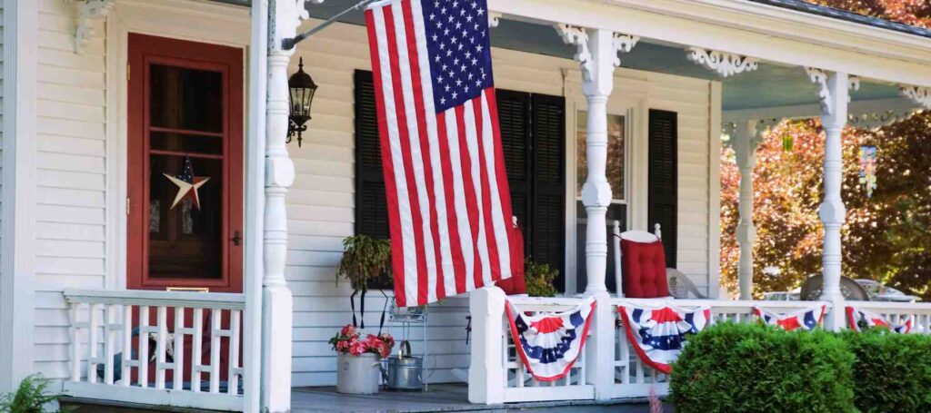 Flags displayed on the front porch of a home. Fourth of July home decorating