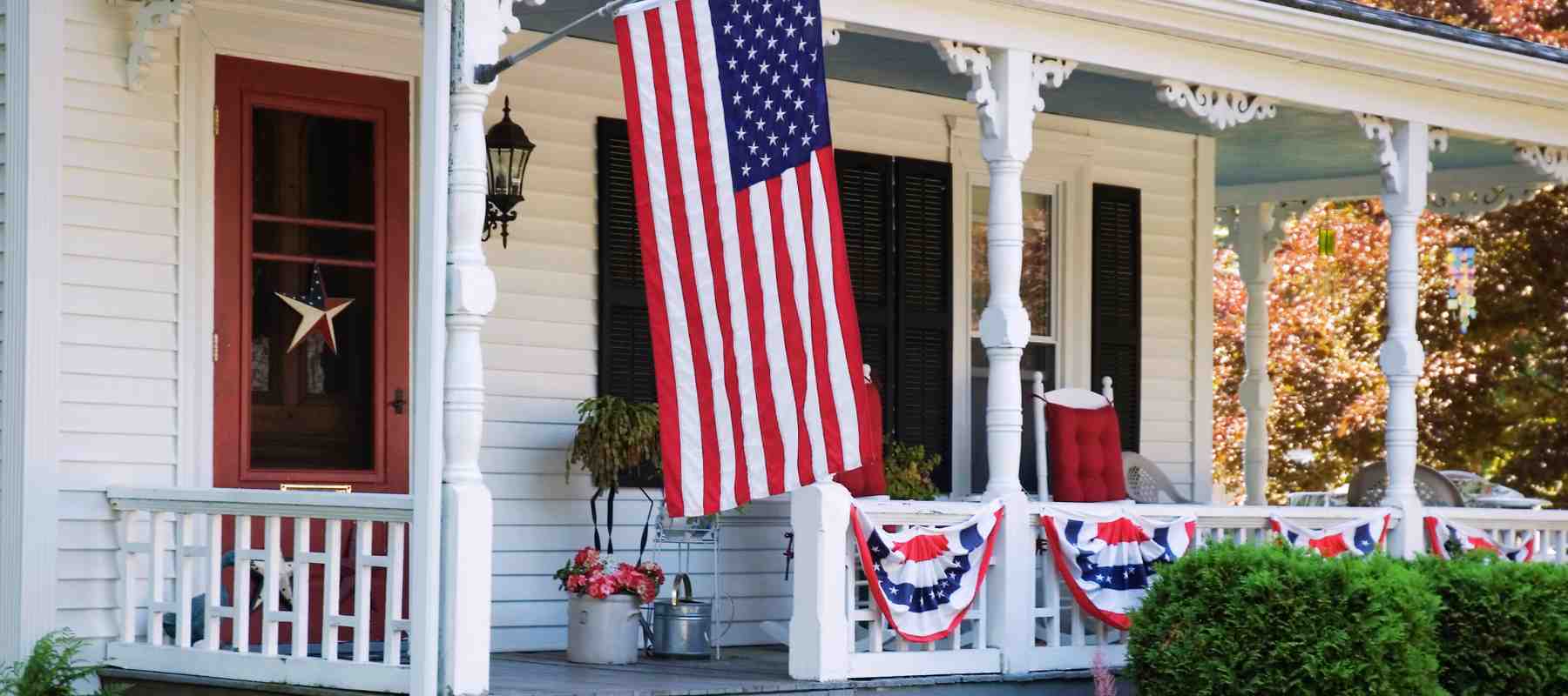 Flags displayed on the front porch of a home. Fourth of July home decorating